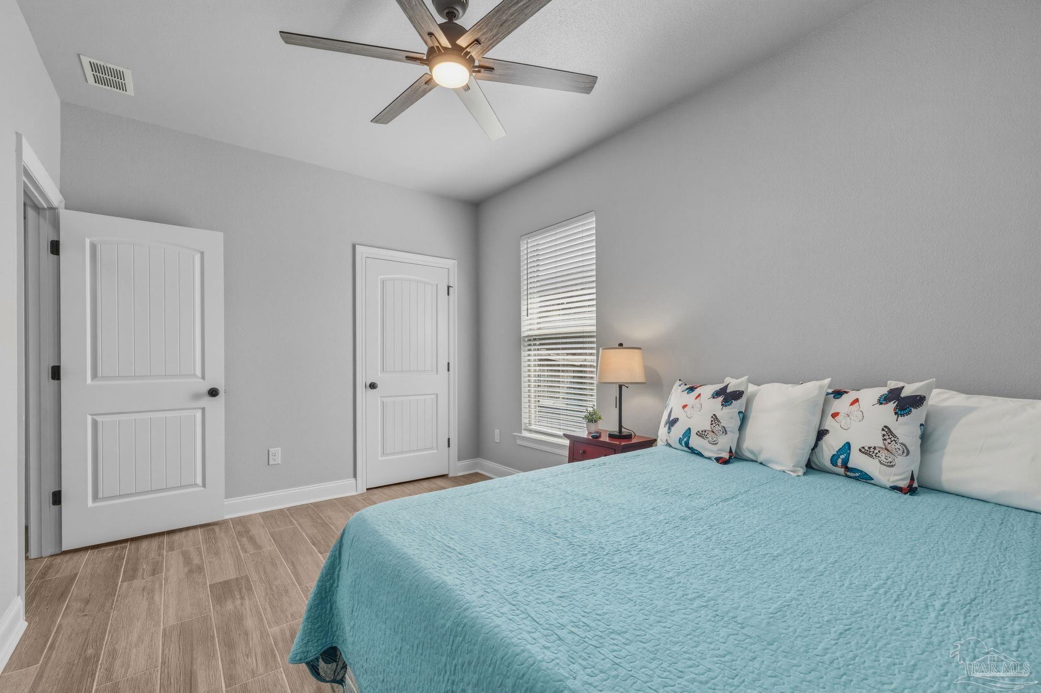 2129 Eagles Rdg Cove Cantonment, FL 32533 - Photo 34 of 66 a bedroom with a large bed and a chandelier