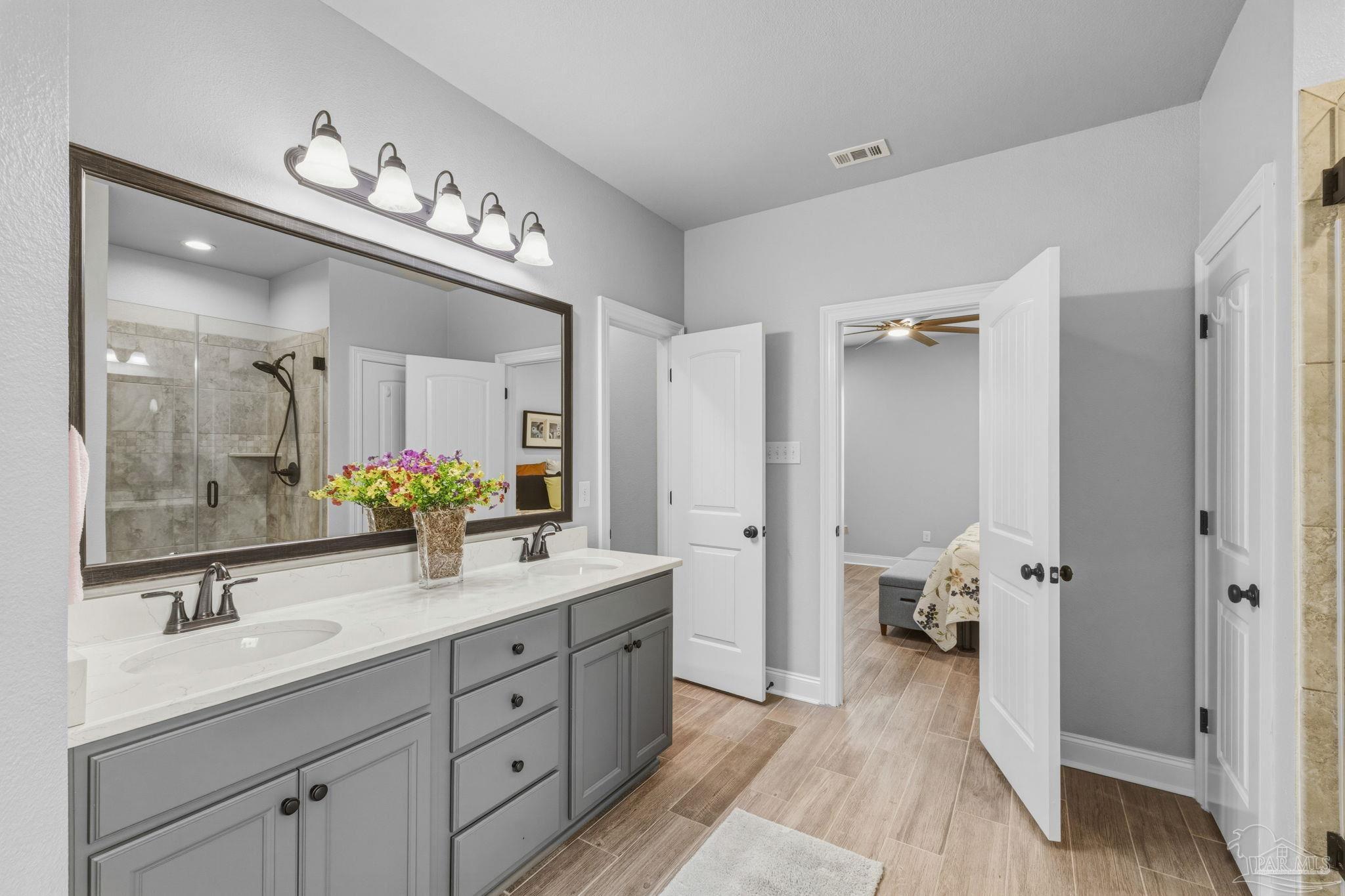 2129 Eagles Rdg Cove Cantonment, FL 32533 - Photo 40 of 66 a spacious bathroom with a double vanity sink a mirror and a shower