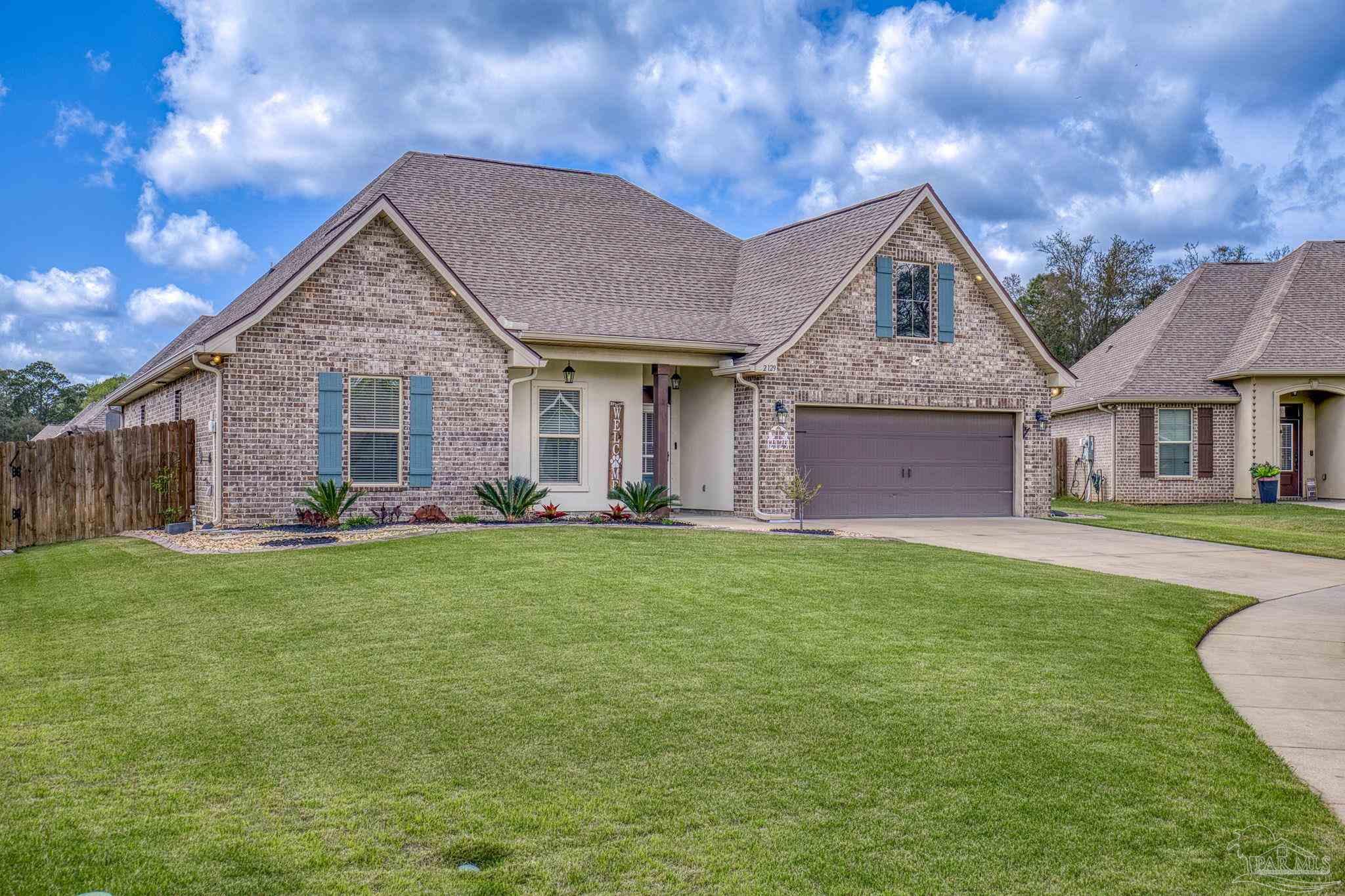 2129 Eagles Rdg Cove Cantonment, FL 32533 - Photo 60 of 66 a front view of a house with a garden and porch