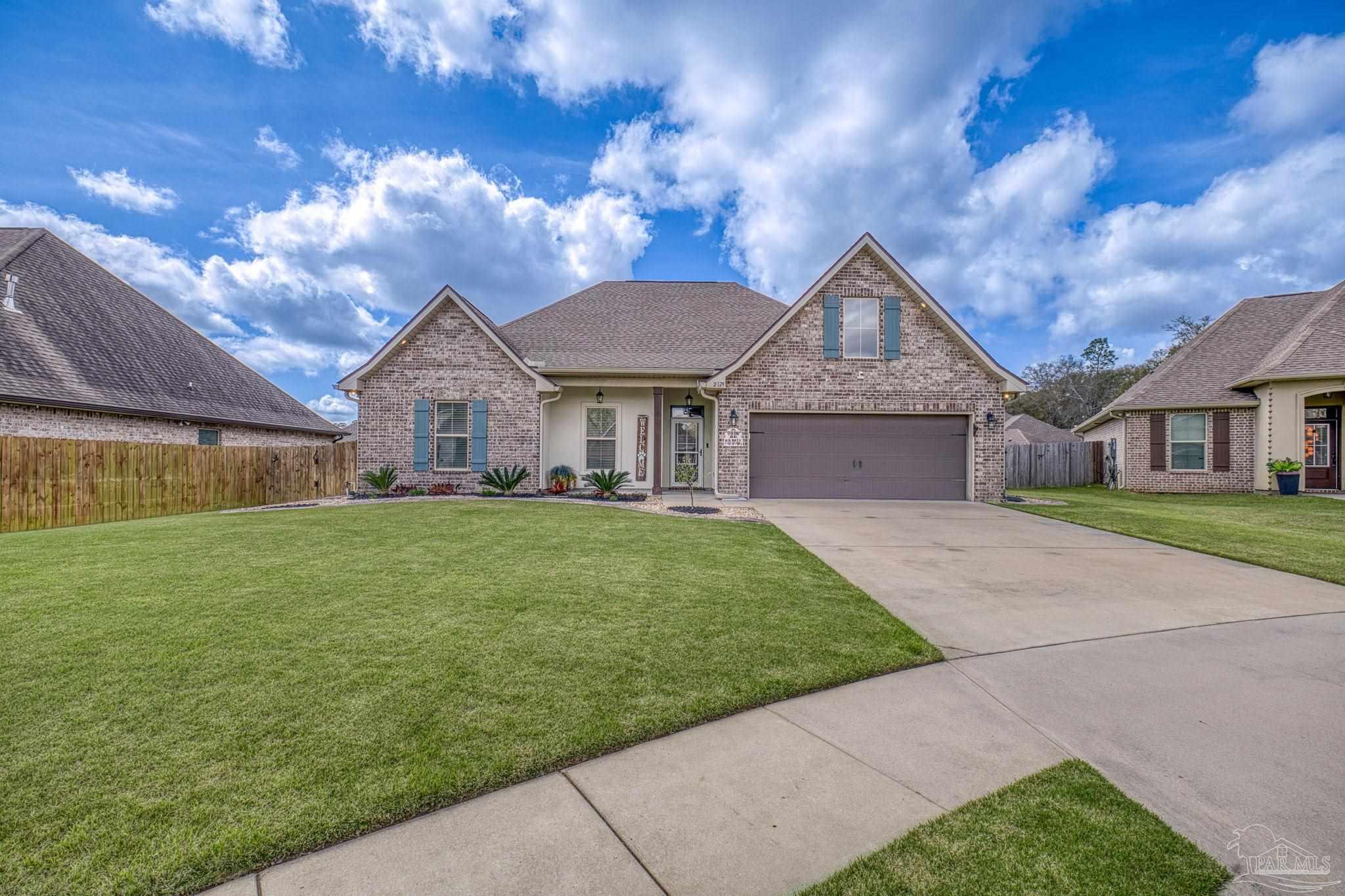 2129 Eagles Rdg Cove Cantonment, FL 32533 - Photo 62 of 66 a front view of a house with a garden and yard