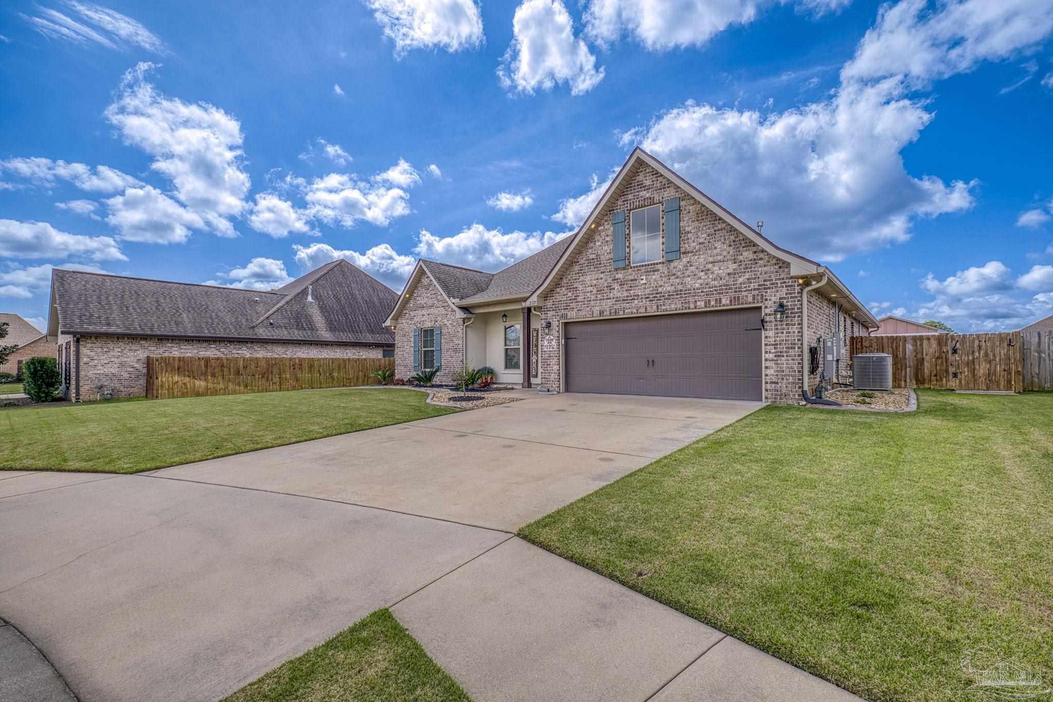 2129 Eagles Rdg Cove Cantonment, FL 32533 - Photo 63 of 66 a front view of a house with a yard and garage