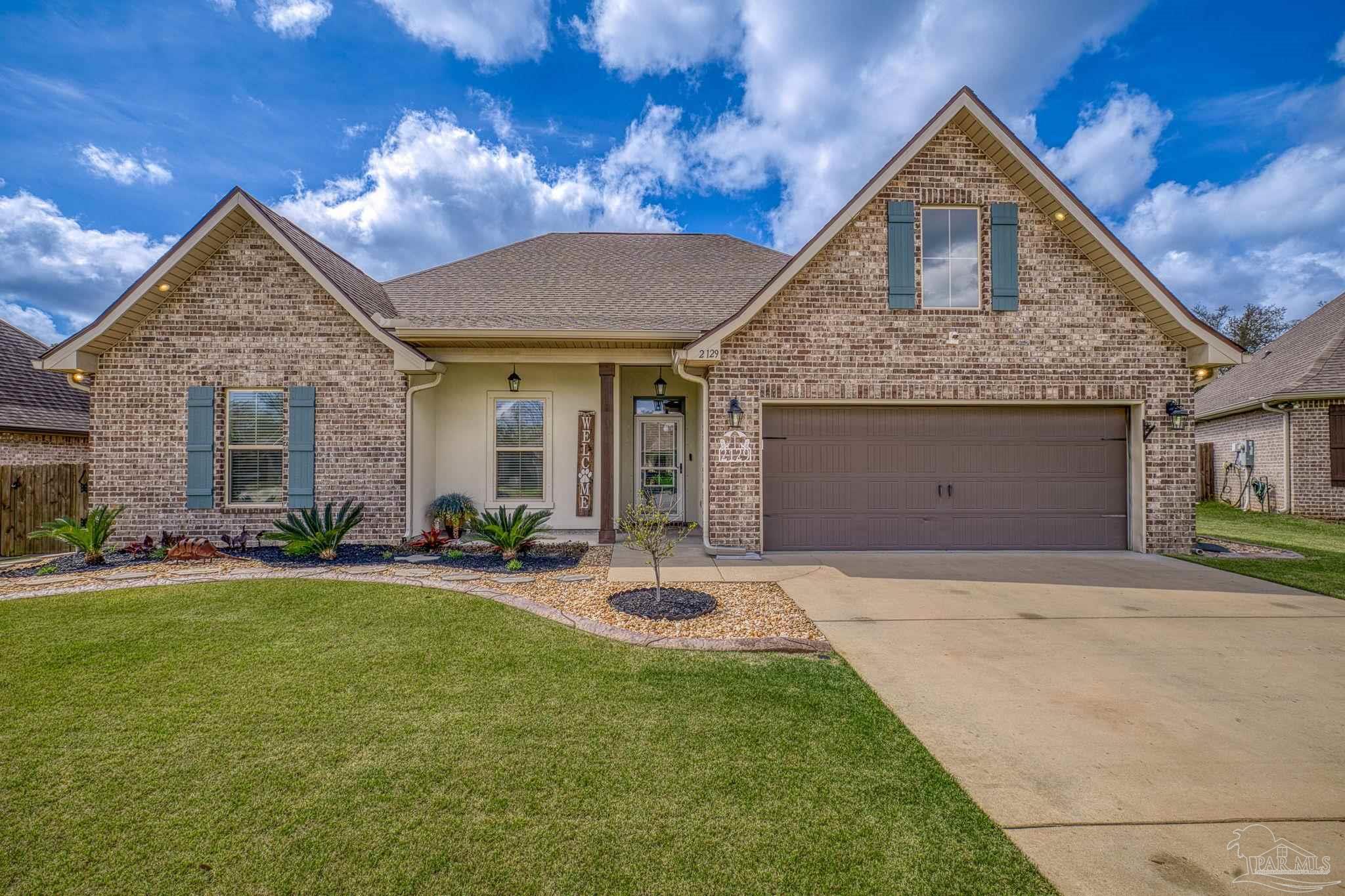 2129 Eagles Rdg Cove Cantonment, FL 32533 - Photo 64 of 66 a front view of a house with a yard and garage