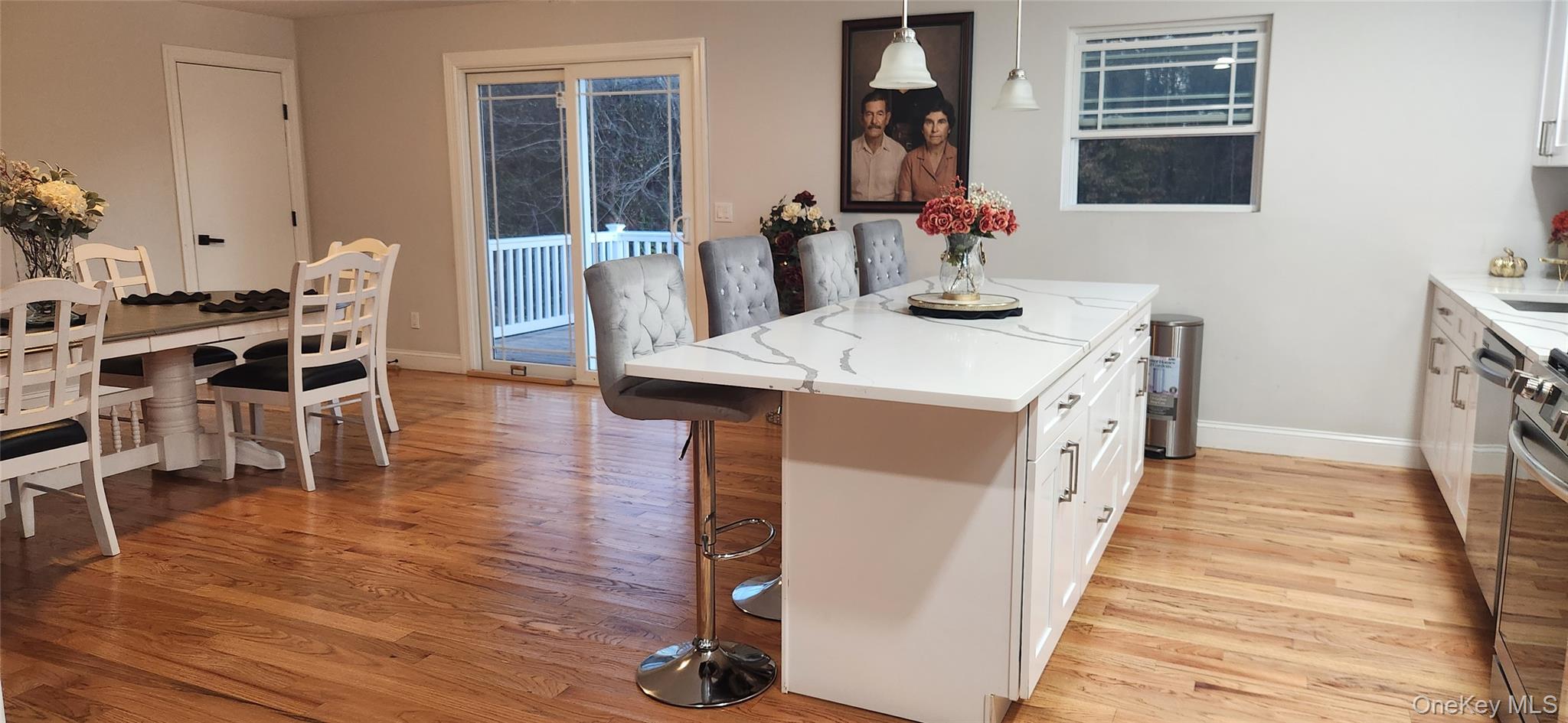 466 Granny Road Medford, NY 11763 - Photo 2 of 14 a dining hall with stainless steel appliances kitchen island granite countertop wooden floor a dining table and chairs