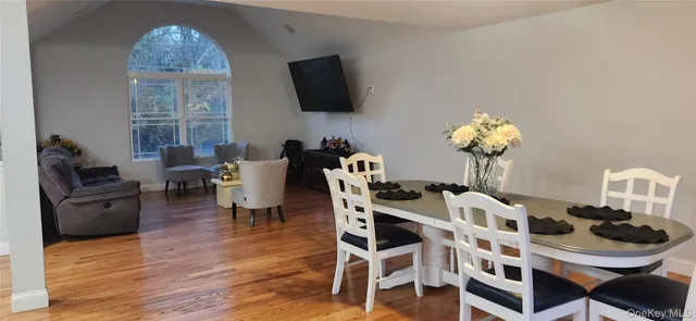 a dining room with furniture a window and wooden floor