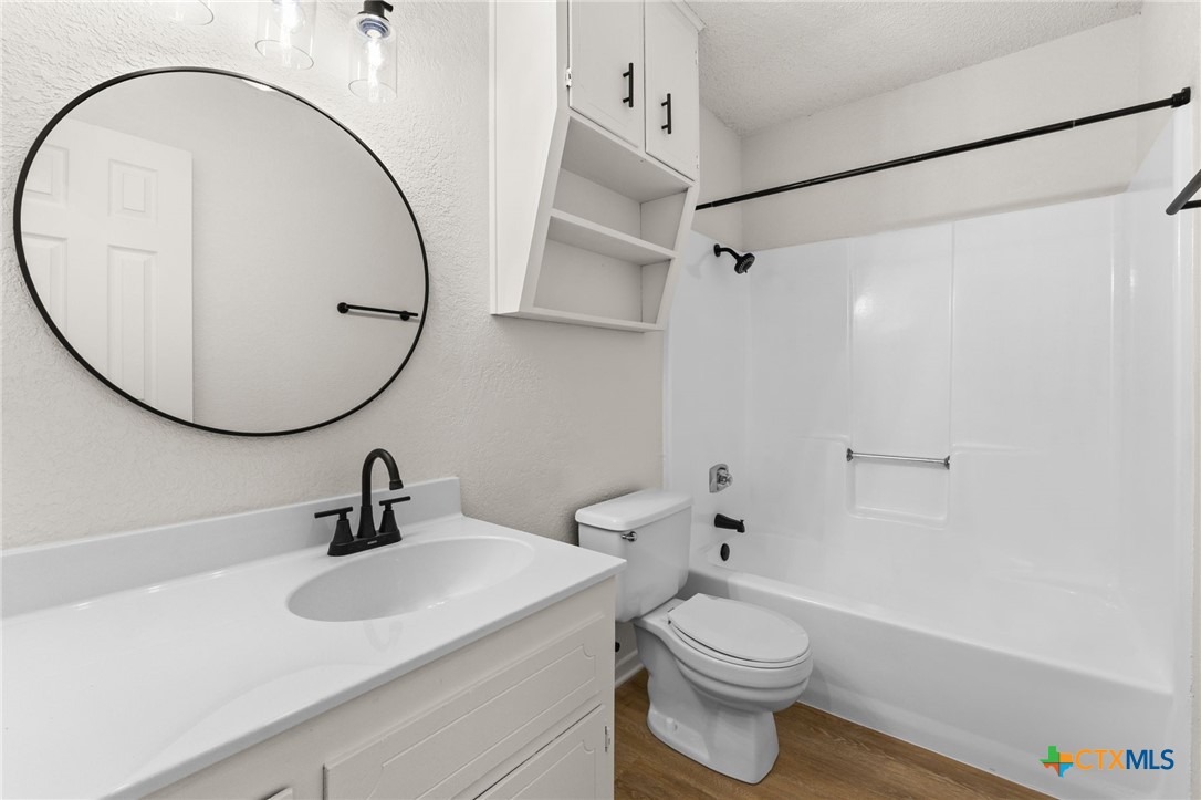 1005 Eastside Drive, Unit D Killeen, TX 76543 - Photo 8 of 9 a bathroom with a sink a toilet and a mirror