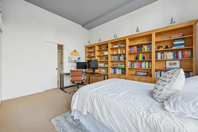 a bedroom with a bed and a book shelf