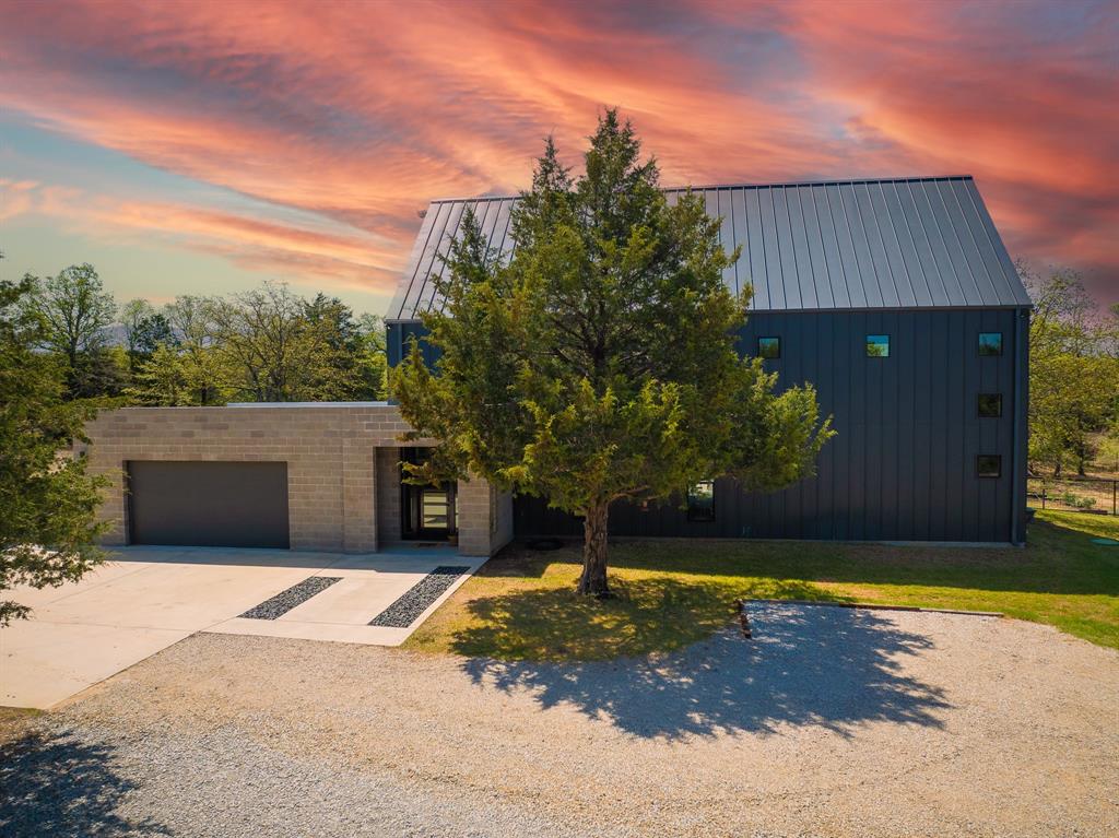 1339 County Road 1111 Decatur, TX 76234 - Photo 1 of 1 View of front facade featuring an attached garage, a yard, driveway, and metal roof