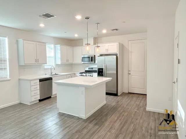 a kitchen with a sink cabinets stainless steel appliances and a window
