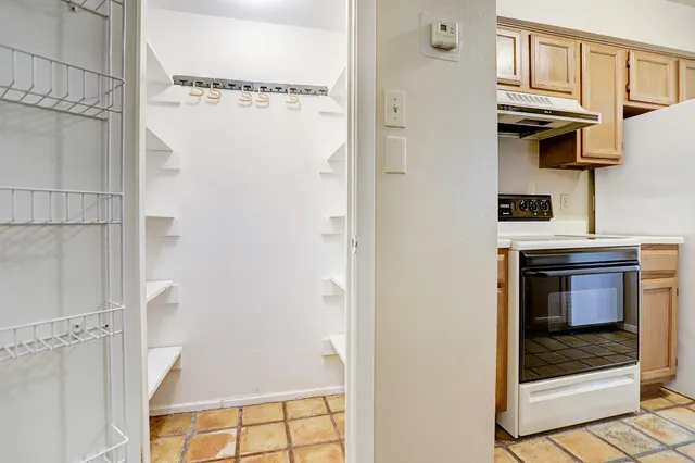 a kitchen with a refrigerator and white cabinets