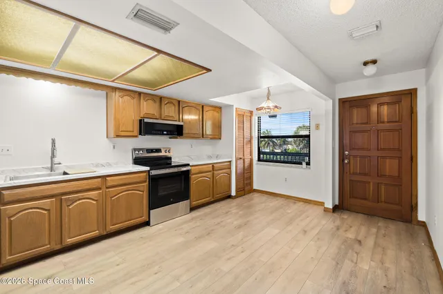a kitchen with stainless steel appliances granite countertop a refrigerator and a stove top oven