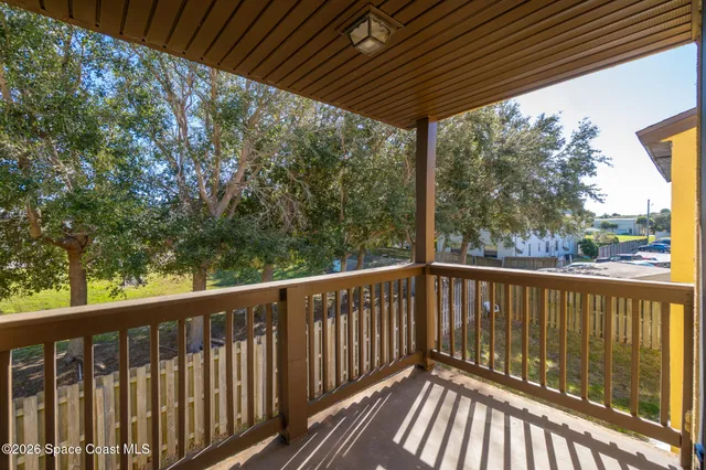 a view of a wooden deck next to a yard