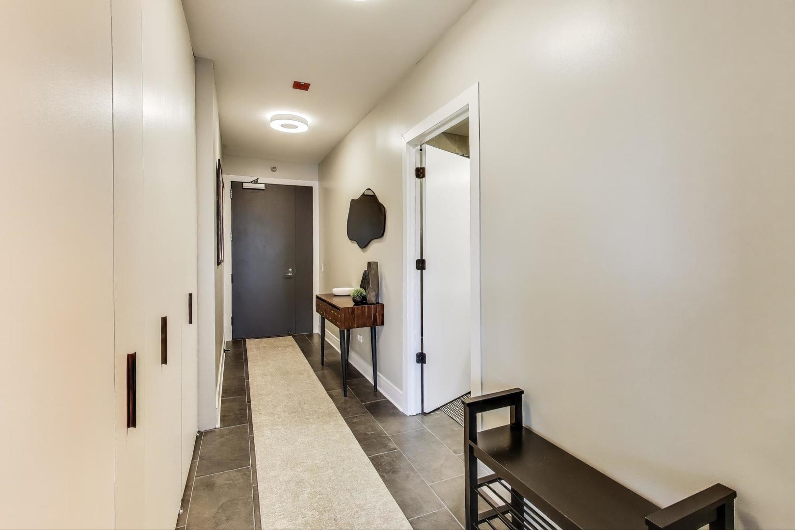 501 North Clinton Street, Unit 1707 Chicago, IL 60654 - Photo 24 of 43 a view of a hallway with wooden floor and a bathroom