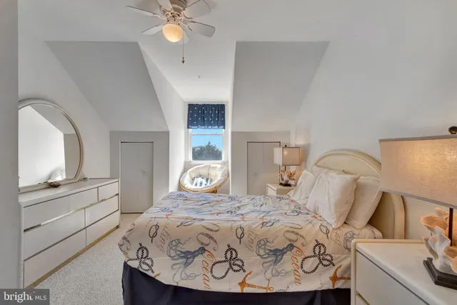 a bedroom with a bed and a flat tv screen on dresser