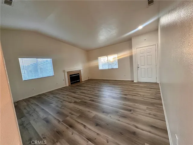 a kitchen with stainless steel appliances wooden floors and a stove top oven
