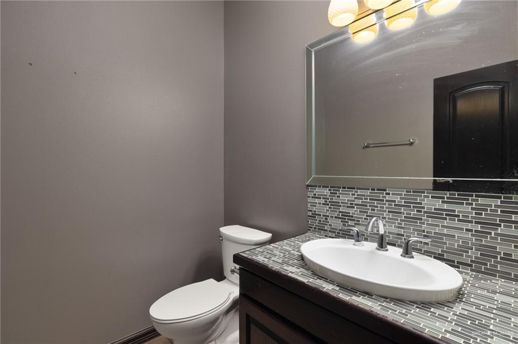 401 Ric Mar Street Edinburg, TX 78541 - Photo 13 of 18 Bathroom featuring a modern vanity with an oval vessel sink, chrome faucet, and mosaic tile backsplash