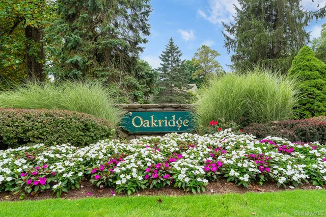 a view of sign board with yard and flowers