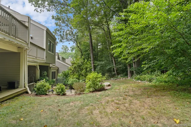 a backyard of a house with plants and large trees