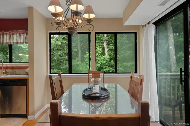a dining room with furniture a large window and a chandelier