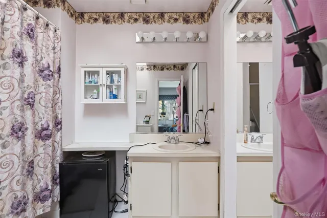 a bathroom with a sink vanity and a mirror