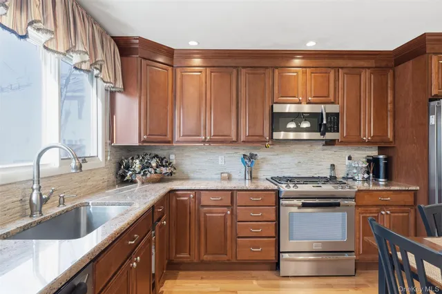 a kitchen with stainless steel appliances granite countertop a sink stove and microwave