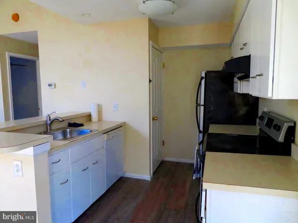 a kitchen with a sink and wooden floor