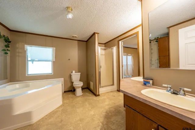 a spacious bathroom with a granite countertop sink mirror and a bathtub