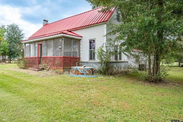 a view of a house with backyard and sitting area