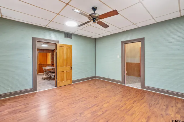 an empty room with a window and wooden floor