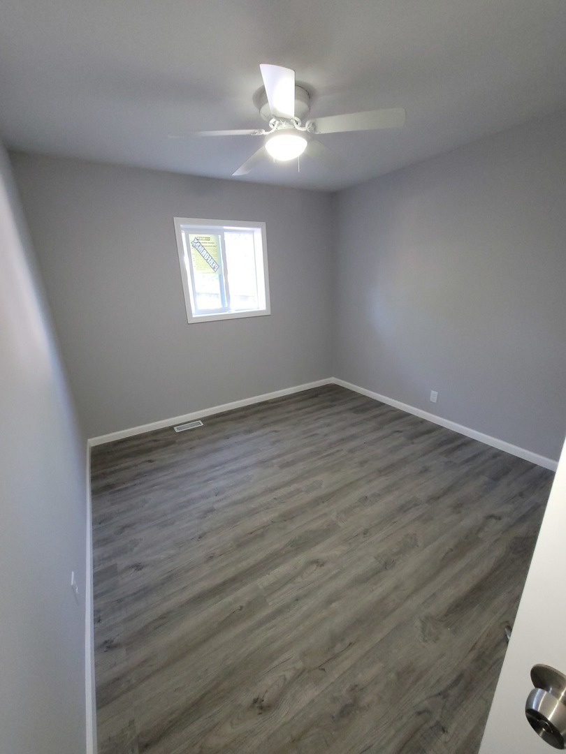 133 Kingston Road Bolingbrook, IL 60440 - Photo 8 of 19 wooden floor in an empty room with a window