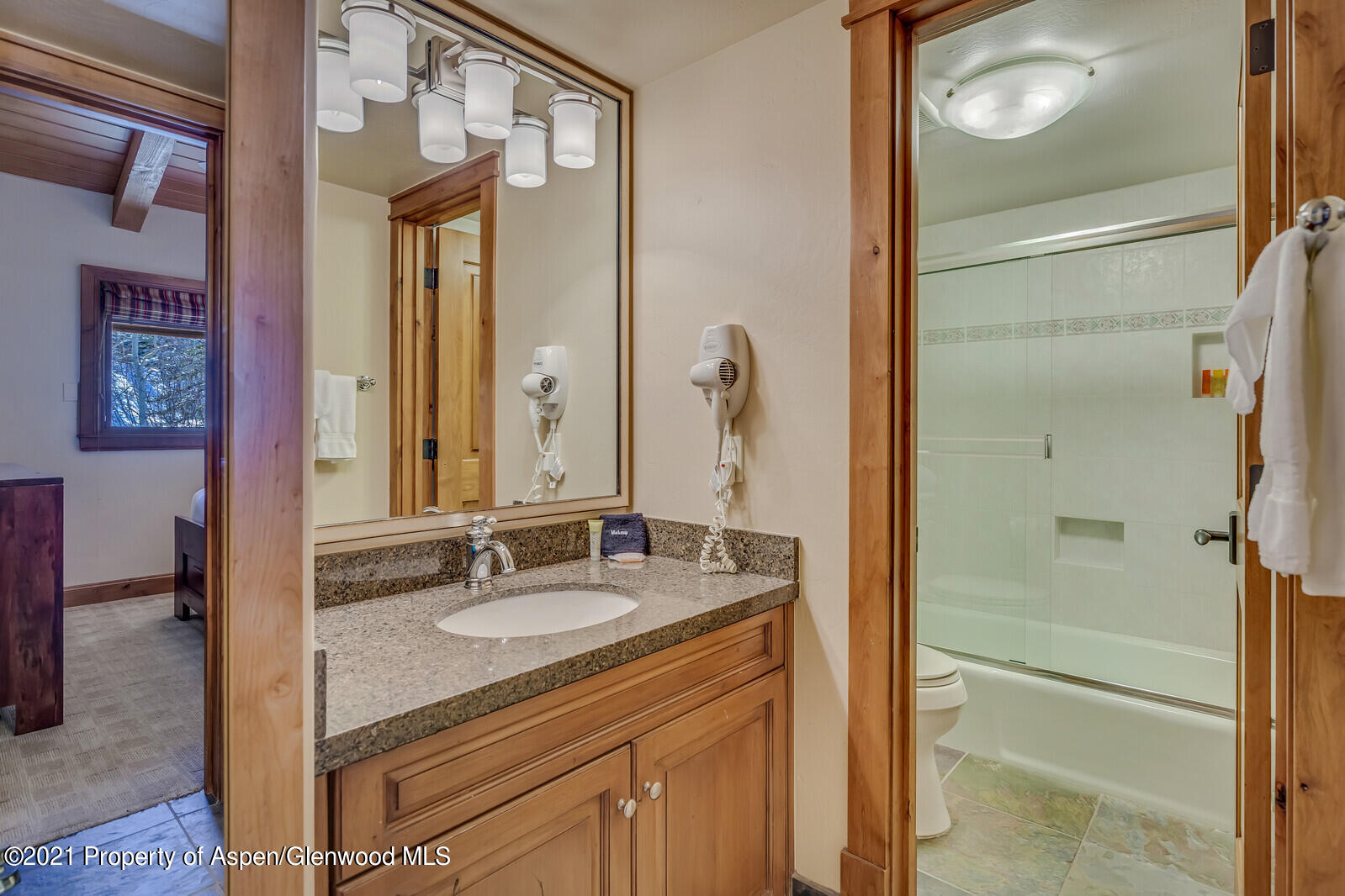 400 Wood Road, Unit 2302 Snowmass Village, CO 81615 - Photo 11 of 16 a bathroom with a granite countertop sink a mirror and a shower