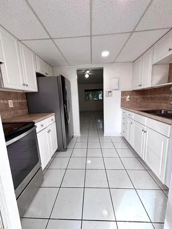 a kitchen with stainless steel appliances granite countertop a sink a stove a microwave and cabinets