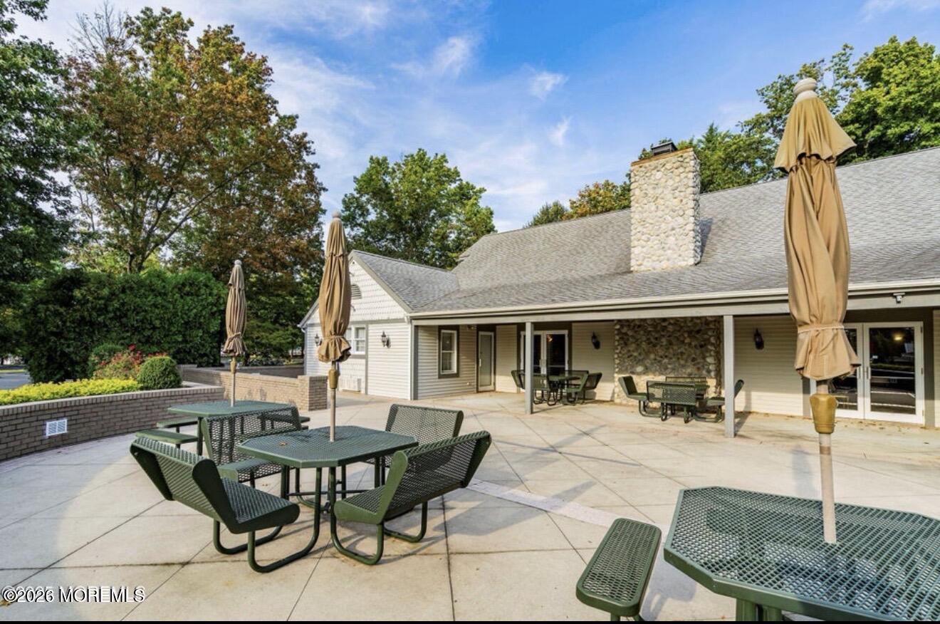 129 Tulip Lane Freehold, NJ 07728 - Photo 23 of 25 a view of a patio with table and chairs potted plants and a large tree