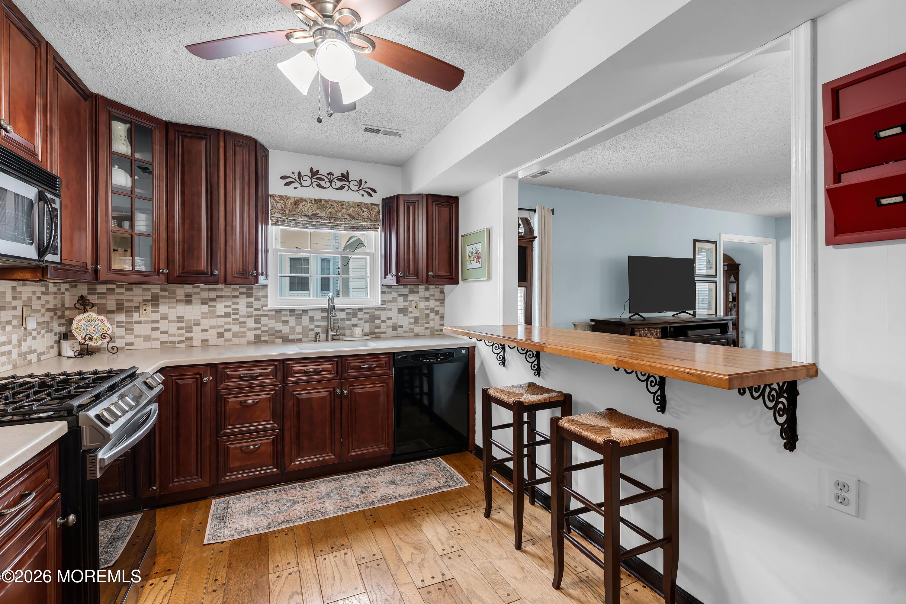 129 Tulip Lane Freehold, NJ 07728 - Photo 6 of 25 a kitchen with stainless steel appliances granite countertop a stove a sink and a microwave