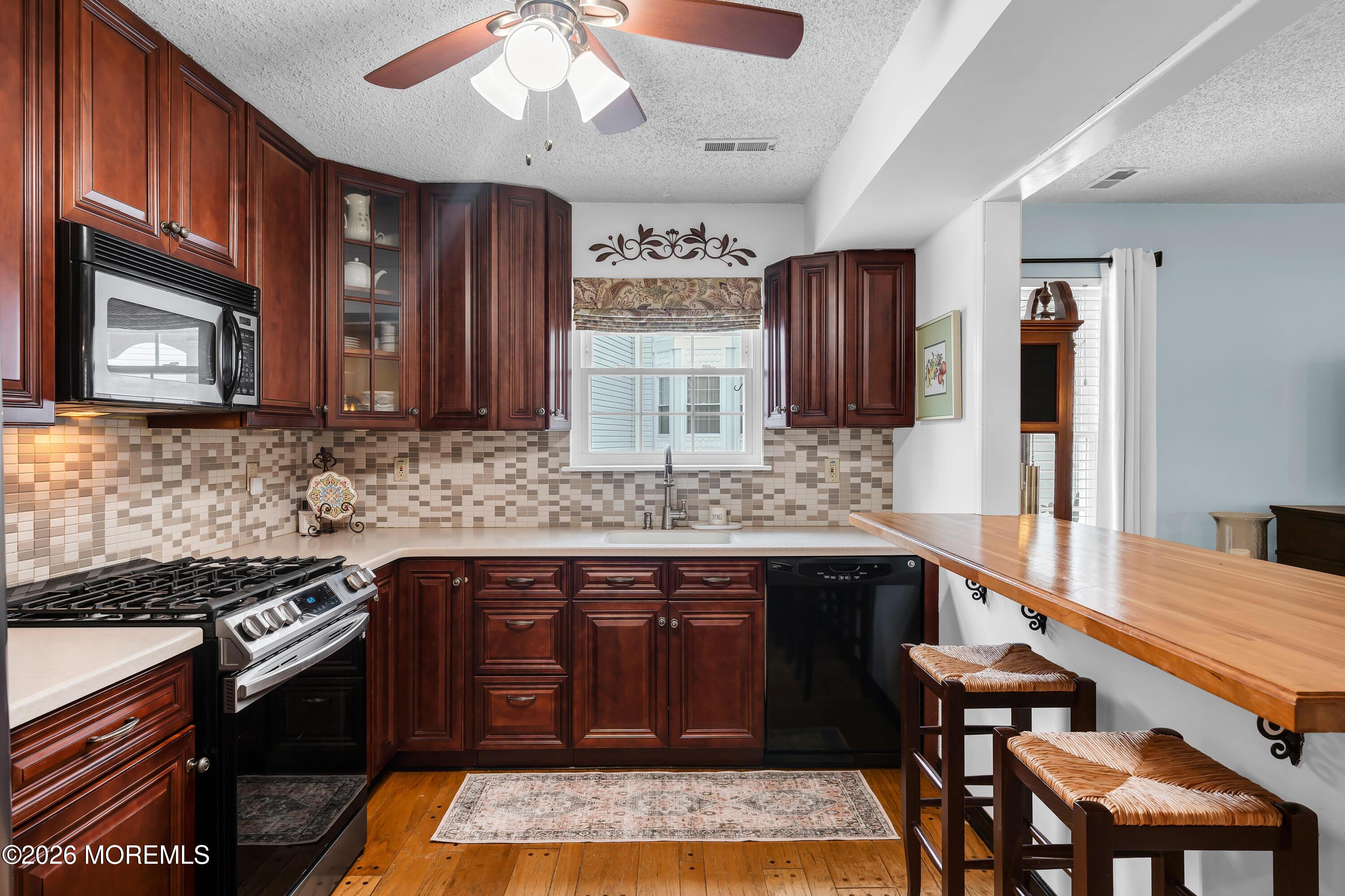 129 Tulip Lane Freehold, NJ 07728 - Photo 7 of 25 a kitchen with stainless steel appliances granite countertop wooden cabinets a stove top oven a sink and dishwasher