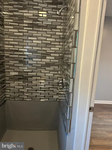 a kitchen with stainless steel appliances granite countertop a stove top oven a refrigerator a sink and dishwasher with wooden floor