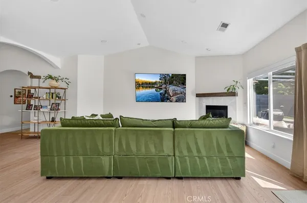 a living room with furniture a large window and a wooden floor