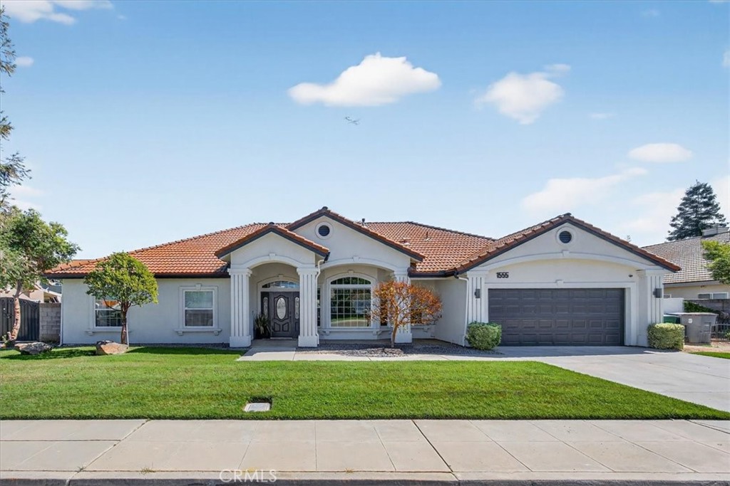 1555 Taylor Street Madera, CA 93637 - Photo 2 of 75 a front view of a house with a garden and yard