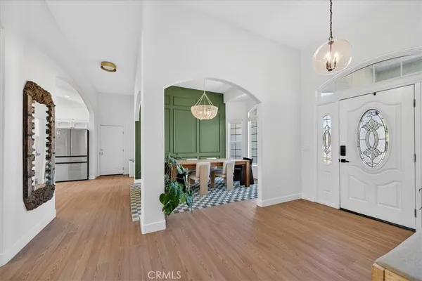 a dining room with furniture a chandelier and wooden floor