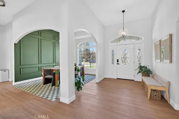 a kitchen with stainless steel appliances granite countertop a refrigerator a stove and white cabinets with wooden floors