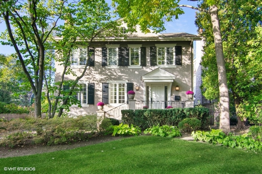 a front view of a house with a garden and plants