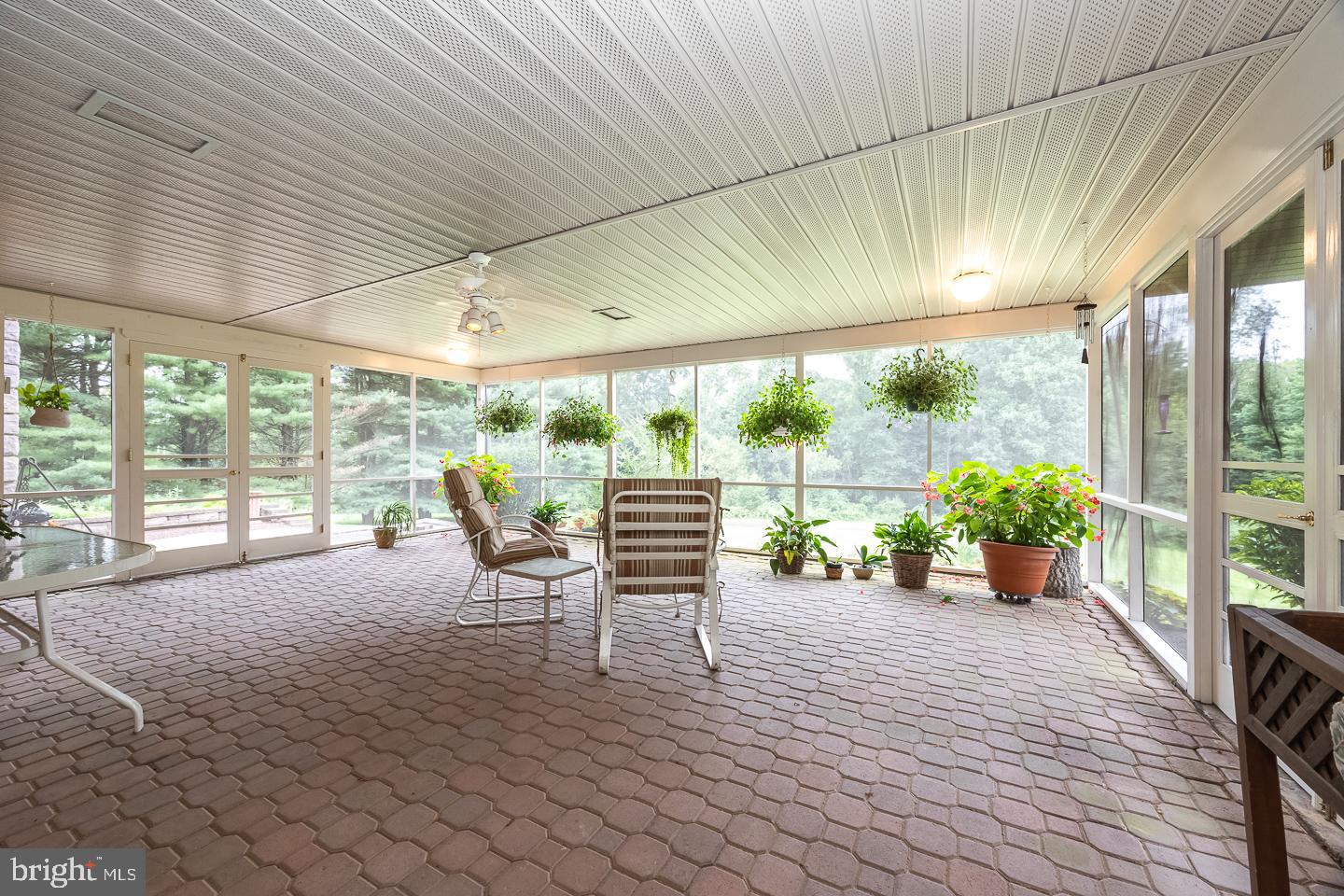 841 Cadmus Road Pottstown, PA 19465 - Photo 42 of 58 a view of a patio with table and chairs potted plants with floor to ceiling window