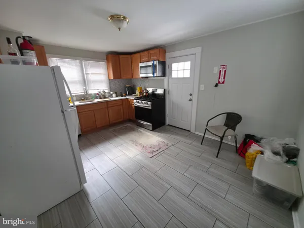 a kitchen with stainless steel appliances kitchen island granite countertop a refrigerator and a sink