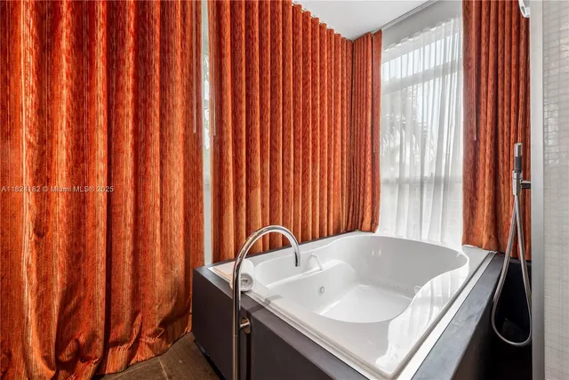 a bathroom with a tub sink and mirror