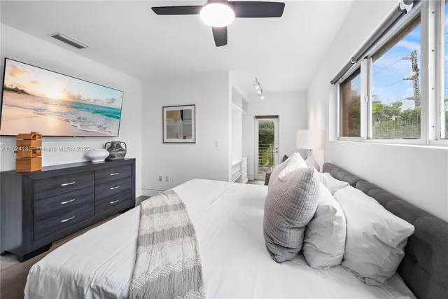 a bedroom with a bed and a large window