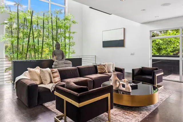 a living room with furniture and a floor to ceiling window
