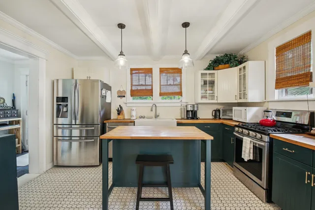 a kitchen with stainless steel appliances a stove a sink refrigerator and a table