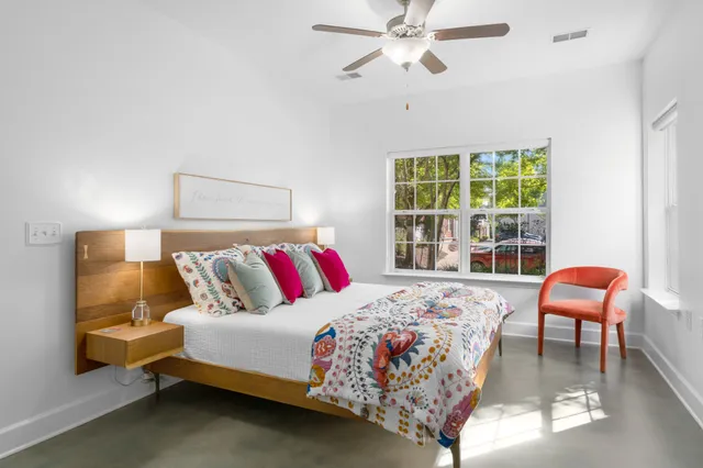 a bedroom with a bed chair and a window