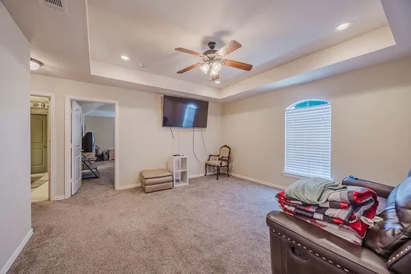 a living room with furniture and a ceiling fan