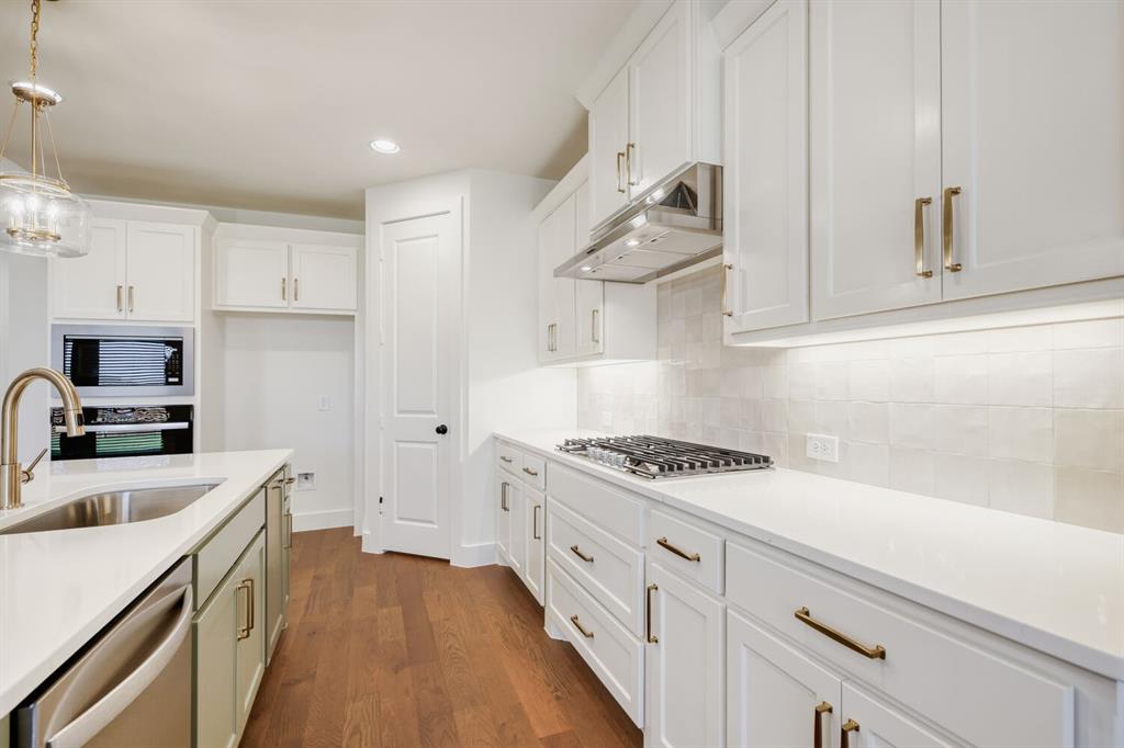 4314 Haley Way Oak Point, TX 75068 - Photo 12 of 28 Gourmet kitchen featuring white shaker cabinetry, stainless steel appliances, a gas cooktop, white countertops, and wood-finish flooring
