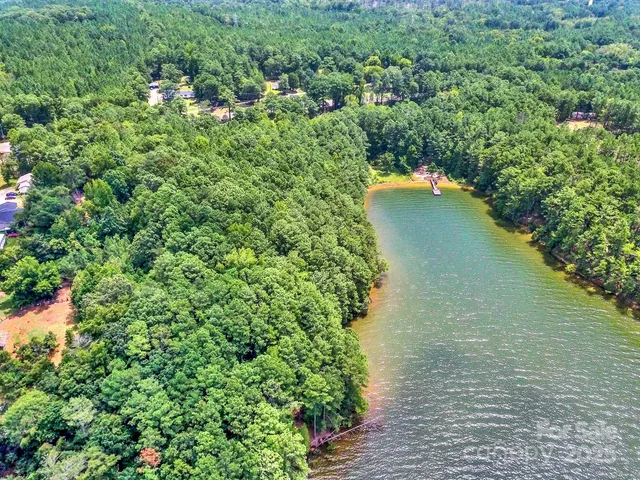 an aerial view of a house with a yard and lake view